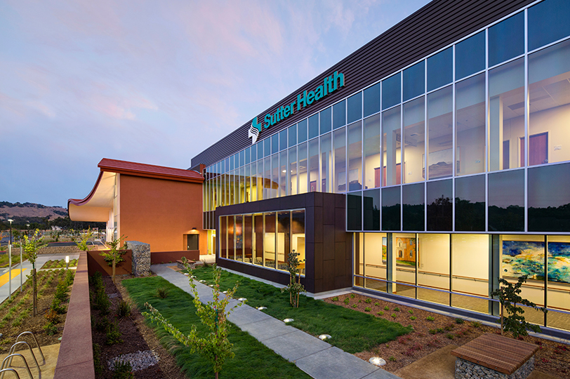 The front of the Sutter Health Regional Hospital building showing large windows and a landscaped outdoor seating area 
