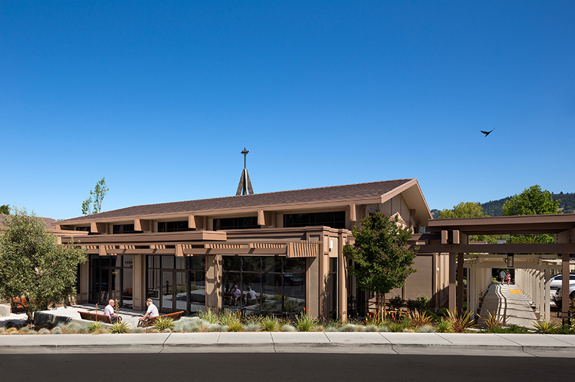 The front view of the Spring Lake Village Skilled Nursing Facility showing a front seating area and covered walkway