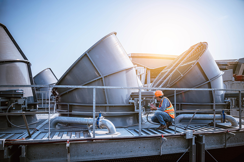 Engineer gathering data on top of a cooling tower