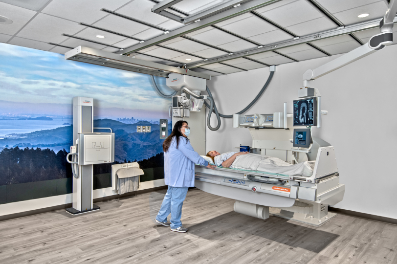 Medical technician preparing patient for diagnostic imaging procedure in modern radiology suite