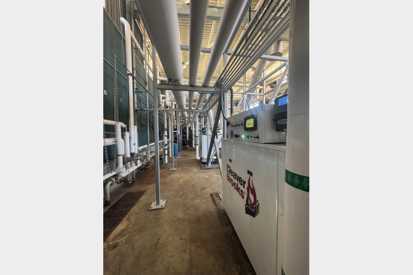 Industrial mechanical corridor with Cleaver Brooks boiler equipment and overhead piping